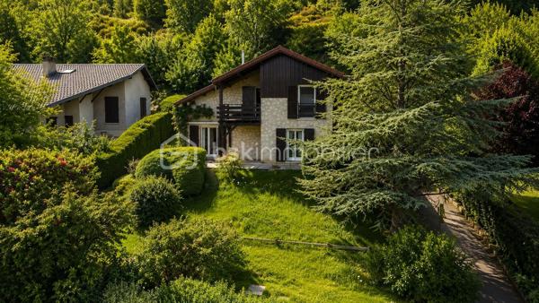 Dans un environnement paisible et verdoyant, découvrez cette belle maison familiale des années 80, située au cœur d’un lotissement calme et recherché de 19 maisons.
Édifiée sur une parcelle arborée de 940 m², elle offre 152 m² habitables (168 m² au sol), une triple exposition et une vue dégagée sur Belledonne et le Vercors.

🌿 Les extérieurs
Le jardin, soigneusement entretenu, bénéficie d’une exposition plein sud et d’une belle intimité.
Vous profiterez de plusieurs terrasses, d’arbres fruitiers (cerisiers, prunier, cognassier, noisetier) et d’un cadre naturel agréable.
Deux places de stationnement  et un garage double complètent l’ensemble.

🏠 Disposition intérieure

Rez-de-chaussée :

Entrée avec placard intégré,
Cuisine aménagée en chêne ouvrant sur terrasse
Salon – salle à manger lumineux avec cheminée à insert et accès direct à la terrasse,
Volets roulants solaires installés en 2017,
Chambre avec accès balcon,
Salle d’eau avec douche à l’italienne et WC (rénovée en 2017),
Pièce cellier/dressing attenante.

Étage :

Accès aux combles aménagés sur la moitié de la surface,
Chambre  avec terrasse et vue dégagée, placards sous pente,
Chambre  avec petit extérieur 
Chambre  sous pente,
Chambre  avec mezzanine fermée et VELUX,
Salle d’eau rénovée en 2019 avec douche à l’italienne et placard,
WC indépendants dans le hall.

⚙️ Équipements et prestations

Toiture entièrement refaite en 2019,
Panneaux photovoltaïques 4 kW
Adoucisseur d’eau,
Ballon d’eau chaude 200 L,
Tableau électrique refait en 2019,
Monte-escalier Stana accès du garage au rez de chausée 
Vide sanitaire,
Cheminée à insert,
Charges de copropriété : env. 130 €/an (entretien du jardin commun et frais de syndic).

❤️ Les +

Environnement calme et résidentiel
Exposition sud et vue panoramique
Maison parfaitement entretenue
Deux salles d’eau modernes
Production solaire et toiture récente
Grand garage double + stationnements extérieurs
Taxe foncière 3188€