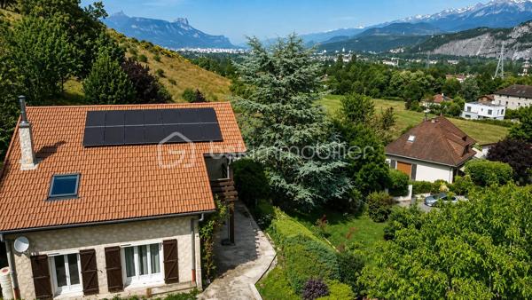 Dans un environnement paisible et verdoyant, découvrez cette belle maison familiale des années 80, située au cœur d’un lotissement calme et recherché de 19 maisons.
Édifiée sur une parcelle arborée de 940 m², elle offre 152 m² habitables (168 m² au sol), une triple exposition et une vue dégagée sur Belledonne et le Vercors.

🌿 Les extérieurs
Le jardin, soigneusement entretenu, bénéficie d’une exposition plein sud et d’une belle intimité.
Vous profiterez de plusieurs terrasses, d’arbres fruitiers (cerisiers, prunier, cognassier, noisetier) et d’un cadre naturel agréable.
Deux places de stationnement  et un garage double complètent l’ensemble.

🏠 Disposition intérieure

Rez-de-chaussée :

Entrée avec placard intégré,
Cuisine aménagée en chêne ouvrant sur terrasse
Salon – salle à manger lumineux avec cheminée à insert et accès direct à la terrasse,
Volets roulants solaires installés en 2017,
Chambre avec accès balcon,
Salle d’eau avec douche à l’italienne et WC (rénovée en 2017),
Pièce cellier/dressing attenante.

Étage :

Accès aux combles aménagés sur la moitié de la surface,
Chambre  avec terrasse et vue dégagée, placards sous pente,
Chambre  avec petit extérieur 
Chambre  sous pente,
Chambre  avec mezzanine fermée et VELUX,
Salle d’eau rénovée en 2019 avec douche à l’italienne et placard,
WC indépendants dans le hall.

⚙️ Équipements et prestations

Toiture entièrement refaite en 2019,
Panneaux photovoltaïques 4 kW
Adoucisseur d’eau,
Ballon d’eau chaude 200 L,
Tableau électrique refait en 2019,
Monte-escalier Stana accès du garage au rez de chausée 
Vide sanitaire,
Cheminée à insert,
Charges de copropriété : env. 130 €/an (entretien du jardin commun et frais de syndic).

❤️ Les +

Environnement calme et résidentiel
Exposition sud et vue panoramique
Maison parfaitement entretenue
Deux salles d’eau modernes
Production solaire et toiture récente
Grand garage double + stationnements extérieurs
Taxe foncière 3188€
