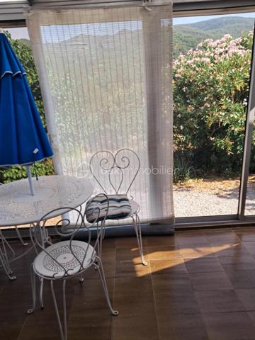 Cette villa est un véritable havre de paix, nichée aux portes de Lamalou les Bains, où la nature s’invite à chaque coin. 
Imaginez-vous dans un joli salon, réchauffé par la douce lumière de la cheminée, où chaque moment passé en famille ou entre amis devient un souvenir précieux. 
La cuisine indépendante, parfaitement équipée, est un espace idéal pour concocter de délicieux repas tout en profitant de la vue apaisante sur le jardin.

Les deux chambres offrent un cocon intime, parfait pour se ressourcer. La salle de bain est un espace de détente, et la buanderie pratique facilite le quotidien (cette dernière peut être transformée en chambre supplémentaire).
La véranda, quant à elle, est un véritable bijou, où vous pourrez savourer votre café du matin tout en admirant le paysage magnifique qui vous entoure.

Avec la climatisation neuve, vous serez à l’aise en toutes saisons. 
Le garage spacieux de 25m² et l’atelier offrent des solutions de rangement idéales pour vos projets personnels.
Et quel bonheur de pouvoir arroser votre jardin grâce au puits, ajoutant une touche de vie à cet écrin de verdure !

La toiture, en excellent état (facture à l'appui)  vous garantit une tranquillité d’esprit. 
C’est une villa où il fait bon vivre, un lieu où chaque détail a été pensé pour votre confort et votre bien-être. Venez découvrir ce petit coin de paradis où chaleur et sérénité se rencontrent.