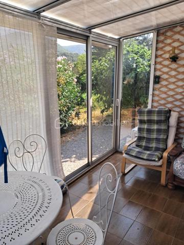Cette villa est un véritable havre de paix, nichée aux portes de Lamalou les Bains, où la nature s’invite à chaque coin. 
Imaginez-vous dans un joli salon, réchauffé par la douce lumière de la cheminée, où chaque moment passé en famille ou entre amis devient un souvenir précieux. 
La cuisine indépendante, parfaitement équipée, est un espace idéal pour concocter de délicieux repas tout en profitant de la vue apaisante sur le jardin.

Les deux chambres offrent un cocon intime, parfait pour se ressourcer. La salle de bain est un espace de détente, et la buanderie pratique facilite le quotidien (cette dernière peut être transformée en chambre supplémentaire).
La véranda, quant à elle, est un véritable bijou, où vous pourrez savourer votre café du matin tout en admirant le paysage magnifique qui vous entoure.

Avec la climatisation neuve, vous serez à l’aise en toutes saisons. 
Le garage spacieux de 25m² et l’atelier offrent des solutions de rangement idéales pour vos projets personnels.
Et quel bonheur de pouvoir arroser votre jardin grâce au puits, ajoutant une touche de vie à cet écrin de verdure !

La toiture, en excellent état (facture à l'appui)  vous garantit une tranquillité d’esprit. 
C’est une villa où il fait bon vivre, un lieu où chaque détail a été pensé pour votre confort et votre bien-être. Venez découvrir ce petit coin de paradis où chaleur et sérénité se rencontrent.