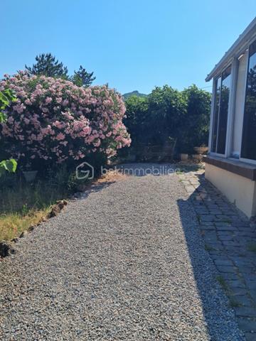 Cette villa est un véritable havre de paix, nichée aux portes de Lamalou les Bains, où la nature s’invite à chaque coin. 
Imaginez-vous dans un joli salon, réchauffé par la douce lumière de la cheminée, où chaque moment passé en famille ou entre amis devient un souvenir précieux. 
La cuisine indépendante, parfaitement équipée, est un espace idéal pour concocter de délicieux repas tout en profitant de la vue apaisante sur le jardin.

Les deux chambres offrent un cocon intime, parfait pour se ressourcer. La salle de bain est un espace de détente, et la buanderie pratique facilite le quotidien (cette dernière peut être transformée en chambre supplémentaire).
La véranda, quant à elle, est un véritable bijou, où vous pourrez savourer votre café du matin tout en admirant le paysage magnifique qui vous entoure.

Avec la climatisation neuve, vous serez à l’aise en toutes saisons. 
Le garage spacieux de 25m² et l’atelier offrent des solutions de rangement idéales pour vos projets personnels.
Et quel bonheur de pouvoir arroser votre jardin grâce au puits, ajoutant une touche de vie à cet écrin de verdure !

La toiture, en excellent état (facture à l'appui)  vous garantit une tranquillité d’esprit. 
C’est une villa où il fait bon vivre, un lieu où chaque détail a été pensé pour votre confort et votre bien-être. Venez découvrir ce petit coin de paradis où chaleur et sérénité se rencontrent.