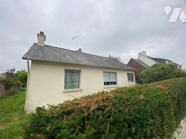 Une maison d'habitation construite en agglomérés de ciment et couverte en ardoises composée : ...
