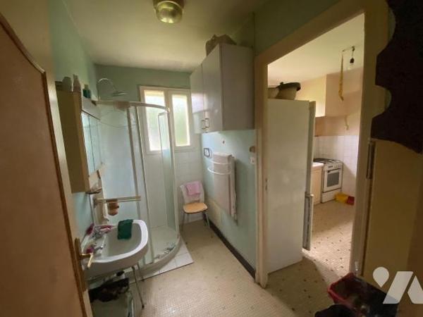 Une maison d'habitation construite en agglomérés de ciment et couverte en ardoises composée : ...