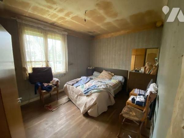 Une maison d'habitation construite en agglomérés de ciment et couverte en ardoises composée : ...