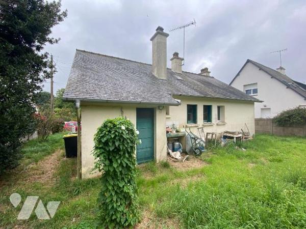 Une maison d'habitation construite en agglomérés de ciment et couverte en ardoises composée : ...