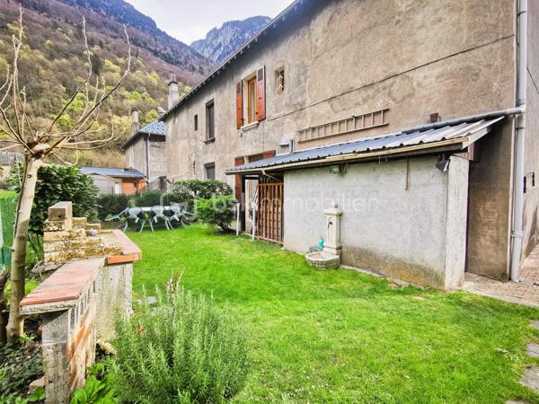 Située dans un environnement paisible sur la commune de Livet-Gavet, cette maison mitoyenne RENOVEE et PLEINE DE CHARME d’environ 109 m² (117 m² au sol) constitue une OPPORTUNITE IDEALE POUR UNE FAMILLE à la recherche de confort et de tranquillité.

Son emplacement est un véritable atout : à deux pas de l’école maternelle, à proximité immédiate de la voie verte et à seulement 19 minutes du téléporté d’Allemond, permettant un accès rapide au domaine skiable de Alpe d’Huez ainsi qu’aux stations prisées de l’Oisans. Un cadre de vie privilégié entre nature, montagne et commodités.

En Rez-de-chaussée un SPACIEUX salon/salle à manger lumineux et chaleureux, offrant un accès au JARDIN FLEURI et à la VUE DEGAGEE; une agréable cuisine attenante donne accès à la TERRASSE DINATOIRE; un WC indépendant.

L' étage propose DEUX CHAMBRES aux belles dimensions; un BUREAU; ainsi qu’une salle d’eau. Les combles aménagés constituent un véritable atout supplémentaire avec une VASTE CHAMBRE DOTEE D'UN DRESSING, pouvant également servir de salle de jeux ou d'espace détente; un ESPACE SUPPLEMENTAIRE à ce niveau vous offre la possibilité de rangements ou d'une pièce en plus à aménager selon vos goûts.

L’extérieur d'environ 100m² présente une TERRASSE DINATOIRE, un joli JARDIN FLEURI à la VUE DEGAGEE, parfait pour des moments de convivialité. De plus, un CABANON,  un GRENIER ainsi que d’une CAVE VOUTEE faisant office de chaufferie, offre un potentiel de stockage appréciable.

Très bien entretenue, la maison bénéficie de prestations techniques de qualité avec une POMPE A CHALEUR récente installée en 2023, des menuiseries en DOUBLE ET TRIPLE VITRAGE, le raccordement au tout-à-l’égout ainsi que la FIBRE; Classée DPE C, elle assure une CONSOMMATION ENERGETIQUE MAITRISEE, idéale pour le confort au quotidien et la maîtrise des dépenses.

Ce bien séduit par son équilibre entre charme, volumes généreux et emplacement stratégique, en faisant une opportunité rare sur le secteur, particulièrement adaptée à une famille grâce à la proximité immédiate des écoles.

Des places de stationnement sont disponibles à proximité et un GARAGE peut être proposé en complément.