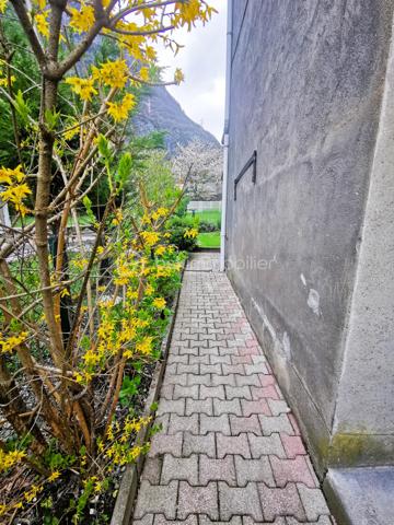 Située dans un environnement paisible sur la commune de Livet-Gavet, cette maison mitoyenne RENOVEE et PLEINE DE CHARME d’environ 109 m² (117 m² au sol) constitue une OPPORTUNITE IDEALE POUR UNE FAMILLE à la recherche de confort et de tranquillité.

Son emplacement est un véritable atout : à deux pas de l’école maternelle, à proximité immédiate de la voie verte et à seulement 19 minutes du téléporté d’Allemond, permettant un accès rapide au domaine skiable de Alpe d’Huez ainsi qu’aux stations prisées de l’Oisans. Un cadre de vie privilégié entre nature, montagne et commodités.

En Rez-de-chaussée un SPACIEUX salon/salle à manger lumineux et chaleureux, offrant un accès au JARDIN FLEURI et à la VUE DEGAGEE; une agréable cuisine attenante donne accès à la TERRASSE DINATOIRE; un WC indépendant.

L' étage propose DEUX CHAMBRES aux belles dimensions; un BUREAU; ainsi qu’une salle d’eau. Les combles aménagés constituent un véritable atout supplémentaire avec une VASTE CHAMBRE DOTEE D'UN DRESSING, pouvant également servir de salle de jeux ou d'espace détente; un ESPACE SUPPLEMENTAIRE à ce niveau vous offre la possibilité de rangements ou d'une pièce en plus à aménager selon vos goûts.

L’extérieur d'environ 100m² présente une TERRASSE DINATOIRE, un joli JARDIN FLEURI à la VUE DEGAGEE, parfait pour des moments de convivialité. De plus, un CABANON,  un GRENIER ainsi que d’une CAVE VOUTEE faisant office de chaufferie, offre un potentiel de stockage appréciable.

Très bien entretenue, la maison bénéficie de prestations techniques de qualité avec une POMPE A CHALEUR récente installée en 2023, des menuiseries en DOUBLE ET TRIPLE VITRAGE, le raccordement au tout-à-l’égout ainsi que la FIBRE; Classée DPE C, elle assure une CONSOMMATION ENERGETIQUE MAITRISEE, idéale pour le confort au quotidien et la maîtrise des dépenses.

Ce bien séduit par son équilibre entre charme, volumes généreux et emplacement stratégique, en faisant une opportunité rare sur le secteur, particulièrement adaptée à une famille grâce à la proximité immédiate des écoles.

Des places de stationnement sont disponibles à proximité et un GARAGE peut être proposé en complément.