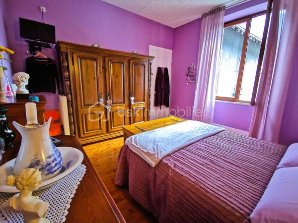 Située dans un environnement paisible sur la commune de Livet-Gavet, cette maison mitoyenne RENOVEE et PLEINE DE CHARME d’environ 109 m² (117 m² au sol) constitue une OPPORTUNITE IDEALE POUR UNE FAMILLE à la recherche de confort et de tranquillité.

Son emplacement est un véritable atout : à deux pas de l’école maternelle, à proximité immédiate de la voie verte et à seulement 19 minutes du téléporté d’Allemond, permettant un accès rapide au domaine skiable de Alpe d’Huez ainsi qu’aux stations prisées de l’Oisans. Un cadre de vie privilégié entre nature, montagne et commodités.

En Rez-de-chaussée un SPACIEUX salon/salle à manger lumineux et chaleureux, offrant un accès au JARDIN FLEURI et à la VUE DEGAGEE; une agréable cuisine attenante donne accès à la TERRASSE DINATOIRE; un WC indépendant.

L' étage propose DEUX CHAMBRES aux belles dimensions; un BUREAU; ainsi qu’une salle d’eau. Les combles aménagés constituent un véritable atout supplémentaire avec une VASTE CHAMBRE DOTEE D'UN DRESSING, pouvant également servir de salle de jeux ou d'espace détente; un ESPACE SUPPLEMENTAIRE à ce niveau vous offre la possibilité de rangements ou d'une pièce en plus à aménager selon vos goûts.

L’extérieur d'environ 100m² présente une TERRASSE DINATOIRE, un joli JARDIN FLEURI à la VUE DEGAGEE, parfait pour des moments de convivialité. De plus, un CABANON,  un GRENIER ainsi que d’une CAVE VOUTEE faisant office de chaufferie, offre un potentiel de stockage appréciable.

Très bien entretenue, la maison bénéficie de prestations techniques de qualité avec une POMPE A CHALEUR récente installée en 2023, des menuiseries en DOUBLE ET TRIPLE VITRAGE, le raccordement au tout-à-l’égout ainsi que la FIBRE; Classée DPE C, elle assure une CONSOMMATION ENERGETIQUE MAITRISEE, idéale pour le confort au quotidien et la maîtrise des dépenses.

Ce bien séduit par son équilibre entre charme, volumes généreux et emplacement stratégique, en faisant une opportunité rare sur le secteur, particulièrement adaptée à une famille grâce à la proximité immédiate des écoles.

Des places de stationnement sont disponibles à proximité et un GARAGE peut être proposé en complément.