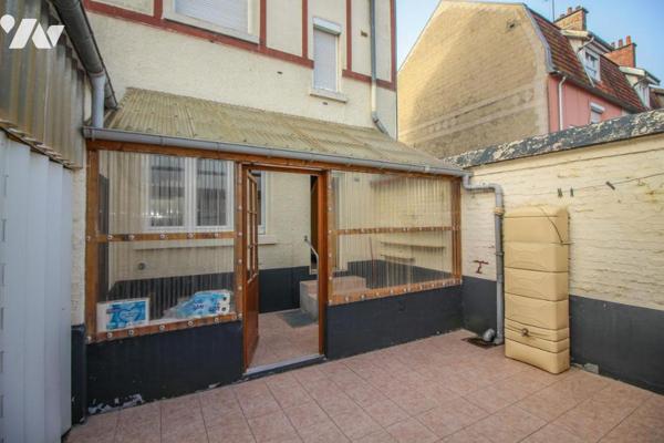 Maison avec jardin et garage.