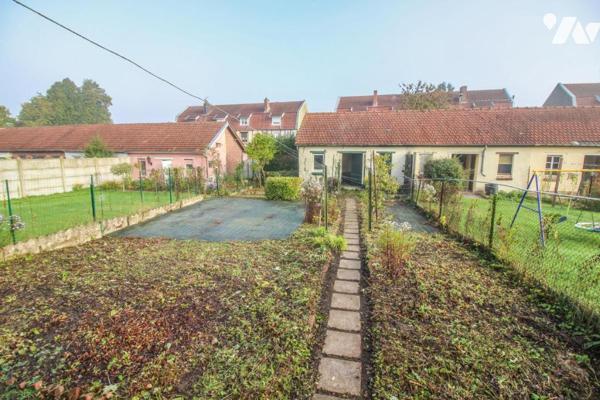 Maison avec jardin et garage.