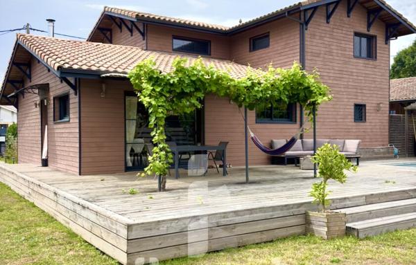 Maison en bois d’environ 150 m2 sur terrain d’environ 830 m2 avec dépendance et piscine