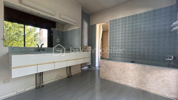 En exclusivité avec Patricia Acquaviva, au cœur du quartier recherché de la Commanderie à Échirolles, découvrez cette spacieuse maison familiale construite en 1969 développant environ 200 m² habitables sur une agréable parcelle de 647 m², offrant de beaux volumes et de nombreuses possibilités d'aménagement.

Dès l'entrée, vous serez séduits par son potentiel et sa configuration idéale pour accueillir une grande famille ou un projet de vie multigénérationnel.

Le rez-de-chaussée se compose d'une belle entrée desservant une chambre, un séjour, une salle d'eau, un WC indépendant, une buanderie ainsi qu'une chaufferie. Vous bénéficierez également de deux garages dont un directement intégré à la maison avec porte motorisée et un second aménagé dans une dépendance en bois.

À l'étage, vous profiterez d'un lumineux séjour ouvrant sur une terrasse et un balcon, d'une cuisine indépendante pouvant facilement être ouverte sur la pièce de vie selon vos envies, de trois chambres dont une véritable suite parentale avec sa salle de bain privative, d'une salle d'eau supplémentaire ainsi que d'un WC indépendant.

Des combles viennent compléter l'ensemble et offrent un espace de stockage appréciable.

Un studio indépendant d'environ 23 m² avec kitchenette, salle d'eau et WC constitue un véritable atout pour accueillir famille et amis, exercer une activité professionnelle ou envisager un revenu locatif complémentaire.

Cette maison représente une opportunité intéressante pour un investissement locatif, la création de plusieurs logements indépendants ou encore pour un projet familial multigénérationnel permettant à chacun de conserver son autonomie tout en partageant un même lieu de vie.

Côté prestations, la maison est équipée de menuiseries en aluminium et PVC, de volets roulants électriques sur l'ensemble des ouvertures et est raccordée au tout-à-l'égout. 
Le chauffage est assuré par une chaudière au fioul.

Des travaux sont à prévoir afin de révéler tout le potentiel de cette propriété aux nombreux atouts.

Vous apprécierez enfin sa situation privilégiée à proximité de la rocade, des commerces, des écoles et des commodités tout en profitant d'un environnement agréable et résidentiel.

Une maison pleine de possibilités où chacun pourra imaginer et créer son futur cadre de vie, que ce soit pour une résidence principale familiale, un projet multigénérationnel ou un investissement à forte valeur ajoutée.
Ne tardez pas à venir la découvrir lors d'une visite.