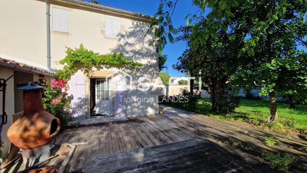 Maison spacieuse avec 3 chambres et jardin arboré.
