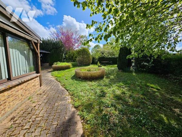 Une maison de ville avec vie de plain-pied,  garage et jardin comprenant : entrée, cuisine, séj...