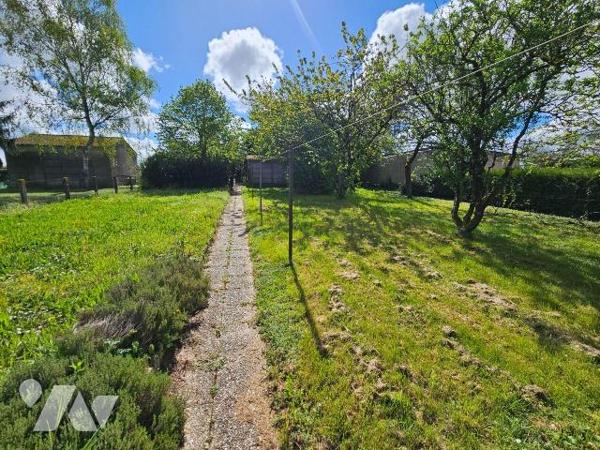 Une maison de ville avec vie de plain-pied,  garage et jardin comprenant : entrée, cuisine, séj...