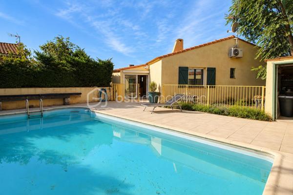 Le calme d’une impasse, le confort du plain-pied et de vrais espaces pour profiter de l’extérieur !

À Milhaud, à proximité de toutes les commodités, découvrez cette maison de plain-pied d’environ 142 m², implantée sur une parcelle arborée de 519 m².

Dès l’entrée, vous découvrirez une maison pleine de vie et de caractère. Sa belle pièce de vie conviviale et lumineuse, ouverte sur le jardin, réunit salon, espace repas et cuisine ouverte, créant un véritable lieu de partage tourné vers l’extérieur.

Côté nuit, la maison dispose de 3 chambres et d’une salle d’eau.

L’ancien garage a été aménagé en buanderie et dressing. Grâce à sa configuration, cet espace offre également un beau potentiel pour créer un bureau, un espace de télétravail ou accueillir une activité libérale à domicile, sous réserve des autorisations nécessaires.

Mais c’est aussi à l’extérieur que cette maison dévoile tout son charme. Le jardin arboré accueille une piscine de 7 x 3,5 m, idéale pour profiter pleinement des beaux jours. Plusieurs dépendances viennent compléter l’ensemble, avec notamment un local technique piscine et atelier, ainsi qu’un agréable espace dédié aux moments de convivialité avec barbecue et cuisine d’été.

Le jardin bénéficie également d’un forage et d’un arrosage automatique, appréciables pour faciliter son entretien.

Pour votre confort au quotidien : pompe à chaleur, climatisation réversible, double vitrage, volets roulants électriques, VMC et accès aux combles.

Une maison chaleureuse et atypique qui offre bien plus que sa surface habitable grâce à ses nombreux espaces complémentaires.

Plain-pied, piscine, dépendances, jardin et calme d’une impasse : une combinaison rare sur Milhaud.

À découvrir sans tarder !