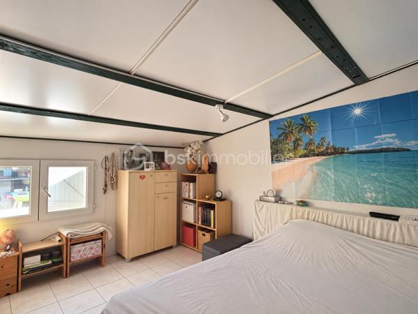 Le calme d’une impasse, le confort du plain-pied et de vrais espaces pour profiter de l’extérieur !

À Milhaud, à proximité de toutes les commodités, découvrez cette maison de plain-pied d’environ 142 m², implantée sur une parcelle arborée de 519 m².

Dès l’entrée, vous découvrirez une maison pleine de vie et de caractère. Sa belle pièce de vie conviviale et lumineuse, ouverte sur le jardin, réunit salon, espace repas et cuisine ouverte, créant un véritable lieu de partage tourné vers l’extérieur.

Côté nuit, la maison dispose de 3 chambres et d’une salle d’eau.

L’ancien garage a été aménagé en buanderie et dressing. Grâce à sa configuration, cet espace offre également un beau potentiel pour créer un bureau, un espace de télétravail ou accueillir une activité libérale à domicile, sous réserve des autorisations nécessaires.

Mais c’est aussi à l’extérieur que cette maison dévoile tout son charme. Le jardin arboré accueille une piscine de 7 x 3,5 m, idéale pour profiter pleinement des beaux jours. Plusieurs dépendances viennent compléter l’ensemble, avec notamment un local technique piscine et atelier, ainsi qu’un agréable espace dédié aux moments de convivialité avec barbecue et cuisine d’été.

Le jardin bénéficie également d’un forage et d’un arrosage automatique, appréciables pour faciliter son entretien.

Pour votre confort au quotidien : pompe à chaleur, climatisation réversible, double vitrage, volets roulants électriques, VMC et accès aux combles.

Une maison chaleureuse et atypique qui offre bien plus que sa surface habitable grâce à ses nombreux espaces complémentaires.

Plain-pied, piscine, dépendances, jardin et calme d’une impasse : une combinaison rare sur Milhaud.

À découvrir sans tarder !