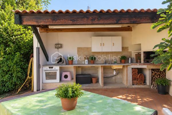 Le calme d’une impasse, le confort du plain-pied et de vrais espaces pour profiter de l’extérieur !

À Milhaud, à proximité de toutes les commodités, découvrez cette maison de plain-pied d’environ 142 m², implantée sur une parcelle arborée de 519 m².

Dès l’entrée, vous découvrirez une maison pleine de vie et de caractère. Sa belle pièce de vie conviviale et lumineuse, ouverte sur le jardin, réunit salon, espace repas et cuisine ouverte, créant un véritable lieu de partage tourné vers l’extérieur.

Côté nuit, la maison dispose de 3 chambres et d’une salle d’eau.

L’ancien garage a été aménagé en buanderie et dressing. Grâce à sa configuration, cet espace offre également un beau potentiel pour créer un bureau, un espace de télétravail ou accueillir une activité libérale à domicile, sous réserve des autorisations nécessaires.

Mais c’est aussi à l’extérieur que cette maison dévoile tout son charme. Le jardin arboré accueille une piscine de 7 x 3,5 m, idéale pour profiter pleinement des beaux jours. Plusieurs dépendances viennent compléter l’ensemble, avec notamment un local technique piscine et atelier, ainsi qu’un agréable espace dédié aux moments de convivialité avec barbecue et cuisine d’été.

Le jardin bénéficie également d’un forage et d’un arrosage automatique, appréciables pour faciliter son entretien.

Pour votre confort au quotidien : pompe à chaleur, climatisation réversible, double vitrage, volets roulants électriques, VMC et accès aux combles.

Une maison chaleureuse et atypique qui offre bien plus que sa surface habitable grâce à ses nombreux espaces complémentaires.

Plain-pied, piscine, dépendances, jardin et calme d’une impasse : une combinaison rare sur Milhaud.

À découvrir sans tarder !
