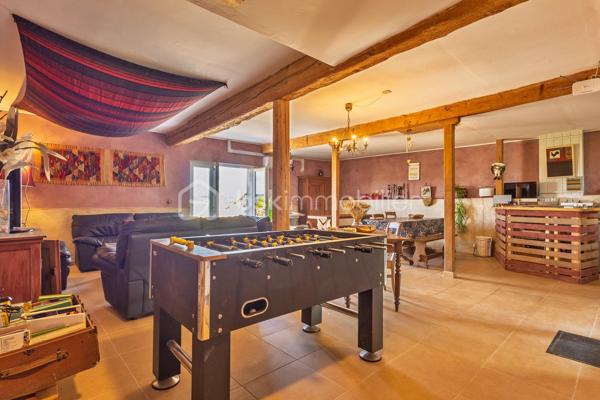Maison de charme avec activité touristique au cœur du Pays Cathare – Proche de Limoux et Carcassonne

Nichée dans le charmant village de Pauligne, au cœur d’un environnement paisible entouré de vignobles, cette magnifique propriété de caractère datant des années 1800 développe environ 405 m² habitables et offre une opportunité rare mêlant qualité de vie et projet touristique immédiatement exploitable.

La partie privative, d’environ 160 m², propose un cadre de vie chaleureux et authentique avec une cuisine équipée, une arrière-cuisine, une salle à manger conviviale, un salon lumineux ainsi qu’une agréable terrasse privée avec vue sur les paysages viticoles. L’espace nuit comprend trois chambres, une salle de bain et une salle d’eau. Un grenier aménageable de 80 m² permet également d’envisager la création de chambres supplémentaires ou d’un espace de vie complémentaire selon vos projets.

La propriété bénéficie depuis plus de 10 ans d’une activité touristique reconnue et immédiatement opérationnelle comprenant :

• un gîte indépendant d’environ 50 m² avec terrasse privative,
• quatre chambres d’hôtes de charme de 18 à 25 m², dont trois avec terrasse et kitchenette,
• une élégante salle de détente et salle à manger de 60 m² prolongée par une terrasse de 30 m² avec vue dégagée.

Les extérieurs, soigneusement aménagés sur environ 1 500 m², invitent à la détente avec une piscine récente au sel chauffée par pompe à chaleur, sécurisée par volet roulant, plusieurs espaces terrasse, un jardin arboré et une superbe vue sur les vignes environnantes.

De nombreuses dépendances complètent l’ensemble :
• garage / atelier de 100 m²,
• garage indépendant de 40 m²,
• cave de 40 m²,
• deux citernes d’eau.

Cette propriété authentique et pleine de charme séduira aussi bien les porteurs de projet touristique que les familles à la recherche d’un lieu de vie exceptionnel dans l’une des régions les plus prisées du sud de la France.

Idéalement située au cœur du Pays Cathare, à proximité de Cité de Carcassonne et de Limoux, la région offre un cadre de vie remarquable entre patrimoine, nature, gastronomie, vignobles et activités de plein air.

Un bien rare alliant art de vivre, authenticité et potentiel de développement.