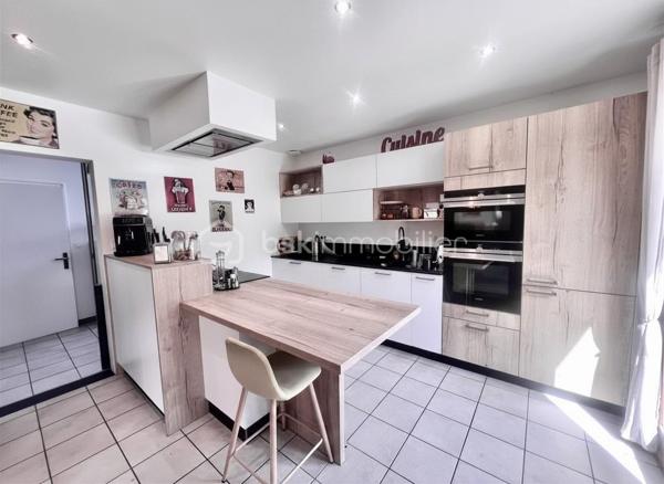Amoureux des lieux atypiques, cette maison est faite pour vous.
Découvrez cette maison d’architecte de 191 m² habitables, offrant 7 pièces aux volumes généreux et aux espaces de vie chaleureux et lumineux, 
le tout implanté sur un terrain de 1 523 m². 
Elle se situe dans un secteur recherché, à proximité des commerces et des stations de ski de la Maurienne.
Exposée plein sud, cette propriété rénovée en 2020 bénéficie d’une belle luminosité naturelle et d’une architecture intérieure originale, 
idéale pour les amateurs de biens authentiques et de caractère.
Édifiée sur deux niveaux, elle séduit dès l’entrée par son vaste hall baigné de lumière, grâce à ses grandes baies vitrées.

Au rez-de-chaussée, vous découvrirez une cuisine entièrement équipée ouverte sur le séjour, avec accès direct à la terrasse extérieure. 
Une magnifique cheminée traversante double foyer vient harmonieusement séparer le séjour du salon, apportant charme et convivialité à l’ensemble.
Le séjour, sublimé par un parquet en bois massif, renforce le caractère chaleureux et raffiné de la maison.
Ce niveau comprend également deux chambres, dont une suite parentale avec salle d’eau privative et accès à une véranda équipée d’une cuisine, 
permettant si besoin de créer un espace indépendant.
Un coin buanderie ainsi qu’un WC séparé viennent compléter ce niveau.
Les belles hauteurs sous plafond et les nombreuses ouvertures accentuent la sensation d’espace et l’atmosphère conviviale de cette propriété unique.

Un élégant escalier mène à l’étage, où vous découvrirez trois chambres confortables, de 13 à 25 m², chacune sublimée par de magnifiques poutres apparentes, 
apportant charme et authenticité.
Vous y trouverez également une salle de bains familiale avec toilettes, ainsi qu’une superbe mezzanine de 25 m², 
habillée d’un parquet massif et aménagée en second salon, surplombant la pièce de vie du rez-de-chaussée et offrant une remarquable sensation d’espace et de volume.

Les extérieurs, soigneusement aménagés, offrent un véritable espace de détente et de convivialité. 
Vous profiterez d’une grande terrasse, d’une piscine au sel chauffée par pompe à chaleur, parfaitement intégrée avec sa terrasse en composite, 
d’un jacuzzi, ainsi que d’un chalet de jardin. 
Le terrain, entièrement clos et paysager, apporte calme et intimité à l’ensemble de la propriété.

Côté dépendances, ce bien dispose également d’un double garage, de deux caves ainsi que d’un carport pouvant accueillir jusqu’à trois véhicules.
Enfin, la maison est équipée de panneaux photovoltaïques, permettant de couvrir une grande partie de la consommation électrique du logement.