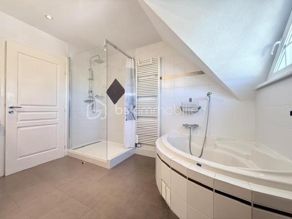 Nichée au cœur d’un quartier résidentiel très recherché, découvrez cette magnifique propriété individuelle de caractère (construction 2002). Accessible par une voie privée garantissant une discrétion absolue, elle offre un cadre de vie rare et privilégié, où confort moderne rhyme avec sérénité. Une véritable maison "prête à vivre", sans aucun travaux à prévoir.

 Des volumes lumineux et harmonieux

Au rez-de-chaussée :
Espace de vie : Un vaste salon-séjour baigné de lumière, ouvert sur une cuisine conviviale et entièrement équipée avec son cellier attenant. Le tout donne un accès direct à la terrasse pour des moments partagés.

Espace de travail : Un vrai bureau, idéal pour le télétravail ou une pièce de lecture.

Accueil : Une entrée fonctionnelle avec placards intégrés et WC invités.

Le plus confort : Chauffage au sol intégral pour une douce chaleur homogène.

À l’étage :

Suite parentale : Un espace élégant avec placards intégrés et sa salle d'eau privative.

Chambres : Deux belles chambres supplémentaires dont une avec placards mural, parfaites pour des enfants ou des invités.

Salle de bain : Une oasis familiale raffinée avec baignoire, douche et double vasque.

Le charme de l'architecture : Les volumes sous toiture apportent un cachet fou et une atmosphère intimiste.

 Un extérieur paysager d'exception
Le jardin de 10,5 ares, soigneusement arboré et entretenu, a été pensé comme une extension de la maison :

Terrasse de 28 m² équipée d'un store motorisé, idéale pour vos repas d'été.

Dépendance : Une coquette maisonnette de jardin de près de 15 m² (atelier, stockage).

Facilité du quotidien : Système d'arrosage automatique pour un vert parfait sans effort.

 Annexes et stationnement haut de gamme
Garage double : Isolé, carrelé, avec porte motorisée (accès direct et propre).

Carport : Capacité de stationnement pour 3 véhicules à l'abri.

Cour : Plusieurs places de stationnement extérieures privatives.

 Prestations techniques & Qualité
Adoucisseur d’eau • Volets roulants électriques • Chauffage au sol • Entretien irréprochable • Matériaux de qualité.

Notre avis : Un bien rare sur le secteur. Si vous recherchez de l'espace, de la tranquillité et des prestations soignées, cette maison d'architecte n'attend plus que vos valises.

Visites privées sur rendez-vous uniquement. Contactez-moi dès aujourd'hui pour planifier votre découverte de ce bien d'exception.