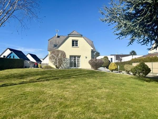 Nichée au cœur d’un quartier résidentiel très recherché, découvrez cette magnifique propriété individuelle de caractère (construction 2002). Accessible par une voie privée garantissant une discrétion absolue, elle offre un cadre de vie rare et privilégié, où confort moderne rhyme avec sérénité. Une véritable maison "prête à vivre", sans aucun travaux à prévoir.

 Des volumes lumineux et harmonieux

Au rez-de-chaussée :
Espace de vie : Un vaste salon-séjour baigné de lumière, ouvert sur une cuisine conviviale et entièrement équipée avec son cellier attenant. Le tout donne un accès direct à la terrasse pour des moments partagés.

Espace de travail : Un vrai bureau, idéal pour le télétravail ou une pièce de lecture.

Accueil : Une entrée fonctionnelle avec placards intégrés et WC invités.

Le plus confort : Chauffage au sol intégral pour une douce chaleur homogène.

À l’étage :

Suite parentale : Un espace élégant avec placards intégrés et sa salle d'eau privative.

Chambres : Deux belles chambres supplémentaires dont une avec placards mural, parfaites pour des enfants ou des invités.

Salle de bain : Une oasis familiale raffinée avec baignoire, douche et double vasque.

Le charme de l'architecture : Les volumes sous toiture apportent un cachet fou et une atmosphère intimiste.

 Un extérieur paysager d'exception
Le jardin de 10,5 ares, soigneusement arboré et entretenu, a été pensé comme une extension de la maison :

Terrasse de 28 m² équipée d'un store motorisé, idéale pour vos repas d'été.

Dépendance : Une coquette maisonnette de jardin de près de 15 m² (atelier, stockage).

Facilité du quotidien : Système d'arrosage automatique pour un vert parfait sans effort.

 Annexes et stationnement haut de gamme
Garage double : Isolé, carrelé, avec porte motorisée (accès direct et propre).

Carport : Capacité de stationnement pour 3 véhicules à l'abri.

Cour : Plusieurs places de stationnement extérieures privatives.

 Prestations techniques & Qualité
Adoucisseur d’eau • Volets roulants électriques • Chauffage au sol • Entretien irréprochable • Matériaux de qualité.

Notre avis : Un bien rare sur le secteur. Si vous recherchez de l'espace, de la tranquillité et des prestations soignées, cette maison d'architecte n'attend plus que vos valises.

Visites privées sur rendez-vous uniquement. Contactez-moi dès aujourd'hui pour planifier votre découverte de ce bien d'exception.