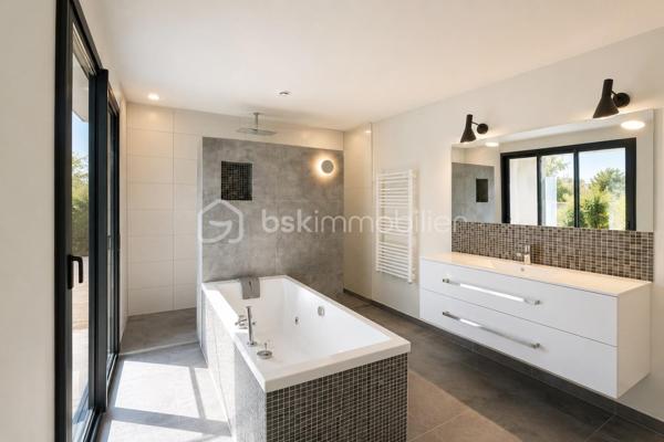 Située à Saint-Gély-du-Fesc, dans un environnement recherché aux portes de Montpellier, cette villa familiale de 205 m² habitables séduit par ses volumes généreux et son organisation pensée pour le confort de chacun.

Principalement de plain-pied, elle propose une belle pièce de vie avec cuisine ouverte sur le séjour, ainsi que des espaces annexes fonctionnels avec cellier et buanderie.

La maison offre 5 chambres, avec une conception rare et particulièrement intéressante :
chaque chambre dispose de sa propre pièce d’eau et bénéficie d’un positionnement indépendant au sein de la maison.

Cette configuration atypique a été imaginée pour offrir à chaque membre de la famille une véritable autonomie, dans un esprit presque “suite privative”. Elle conviendra parfaitement à une famille avec adolescents, à une activité d’accueil, ou encore à des acquéreurs recherchant confort et tranquillité au quotidien.

À l’étage, la suite parentale d’environ 50 m² constitue un véritable espace à part. Elle comprend un dressing, une salle de bains avec douche et baignoire, ainsi qu’un WC indépendant.
Elle s’ouvre également sur une agréable loggia privative, accessible directement depuis la chambre, offrant un espace lumineux.
Une seconde chambre avec pièce d’eau, située à l’opposé, permet d’accueillir confortablement famille ou invités.

À l’extérieur, le jardin accueille une agréable piscine au sel, idéale pour profiter pleinement des beaux jours.

Cette propriété offre ainsi un cadre de vie paisible, alliant volumes, intimité et fonctionnalité.

Saint-Gély-du-Fesc, village dynamique et très recherché, dispose de toutes les commodités : commerces, écoles, collège et ramassage scolaire vers le lycée du Pic Saint-Loup.

Pour tout complément d'information ou pour une visite : Christelle GAUDRON BSK Immobilier au O6 41 66 26 84.