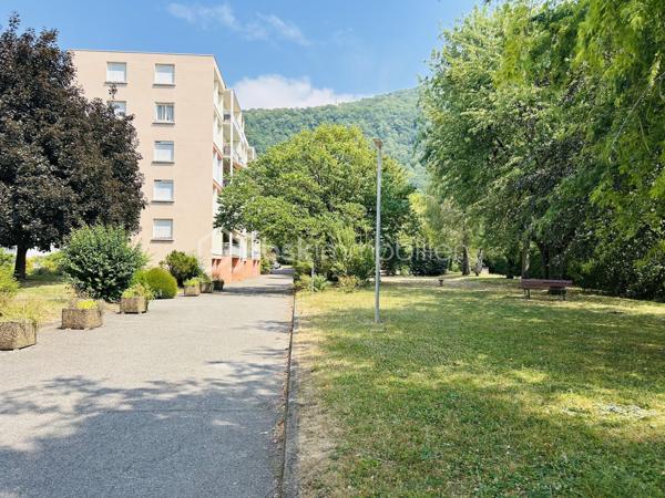 SAINT-MARTIN-D’HÈRES – LIMITE POISAT – T5 TRAVERSANT AVEC BALCON ET CAVE
À proximité immédiate de Poisat, des écoles, commerces et transports, découvrez cet appartement familial de 86,63 m² (Carrez), situé dans la résidence sécurisée et arborée Le Carina, bénéficiant d’un environnement agréable avec espaces verts et jeux pour enfants.
Situé au rez-de-chaussée surélevé (sans ascenseur) et traversant nord-sud, l’appartement offre une distribution fonctionnelle. 
L’entrée avec rangements dessert une cuisine indépendante, prolongée par une loggia, ainsi qu’un séjour ouvrant sur un balcon exposé au sud, sans vis-à-vis direct.
L’espace nuit se compose de quatre chambres, d’une salle d’eau rénovée et de toilettes indépendantes. Une cave de 6,5 m2 complète l’ensemble. Le stationnement est facilité par le parking commun de la résidence (1 place par logement). Le garage de 17 m2 environ (avec électricité) est situé juste en dessous de l’appartement et peut être acquis en supplément.
Côté confort, le logement dispose de la fibre, d’un chauffage individuel au gaz, de menuiseries PVC double vitrage récentes.
Bien entretenu, l’appartement peut être modulé (agrandissement de la pièce de vie en utilisant une chambre) et nécessite quelques travaux de rafraîchissement. Une base saine et un beau potentiel pour créer un intérieur personnalisé, adapté aux besoins d’une famille.
Charges de copropriété : environ 1 200 € par an pour l’appartement. La taxe foncière est de 1850 euros environ (garage compris).