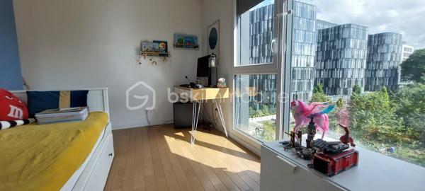 Aux portes de Paris, découvrez ce magnifique appartement 4 pièces situé dans une résidence récente de 2020, parfaitement entretenue et offrant des prestations de qualité.
Dès l'entrée, vous apprécierez les nombreux rangements intégrés ainsi que les volumes harmonieux de cet appartement pensé pour le confort quotidien. Le vaste espace de vie, baigné de lumière grâce à son exposition sud-ouest, s'articule autour d'une élégante cuisine Schmidt semi-ouverte, sublimée par une verrière contemporaine donnant sur l'espace salle à manger.
La pièce de vie se prolonge naturellement vers une loggia de 8,74 m², accessible également depuis la cuisine et l'une des chambres. Véritable espace de détente, elle bénéficie d'une vue entièrement dégagée sur un environnement verdoyant, sans aucun vis-à-vis, offrant un cadre paisible et privilégié.
L'espace nuit comprend trois chambres, dont une confortable suite parentale équipée de placards et de sa propre salle d'eau. Une grande salle de bains indépendante ainsi que des WC séparés complètent parfaitement l'agencement.
Les prestations sont particulièrement soignées : parquet massif, domotique permettant le pilotage à distance du chauffage, des volets roulants et de l'éclairage depuis un smartphone, finitions de qualité et excellent état général de l'appartement comme des parties communes.
Situé à proximité immédiate des crèches, écoles et commerces, ce bien bénéficie également d'une excellente desserte en transports avec la ligne 4 du métro (Lucie Aubrac) accessible à environ 10 minutes à pied et l'arrivée prochaine de la ligne 15 du Grand Paris Express.
Une place de parking en sous-sol accompagne ce bien. Possibilité d'acquérir un box fermé en supplément.
Un appartement clé en main, lumineux et moderne, idéal pour une famille souhaitant profiter d'un cadre de vie agréable tout en restant aux portes de la capitale.