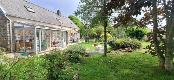 Si vous recherchez l'authenticité de la pierre, du caractère et de l'espace pour toute la famille, cette maison d'environ 98 m² (hors véranda) saura vous séduire. A quelques minutes de Bricquebec, cette maison de caractère avec ses poutres apparentes et ses volumes chaleureux est implantée sur une magnifique parcelle close et arborée de plus de 1 500 m².

​🛋️ Le rez-de-chaussée : De la lumière et du caractère. 🌞

L'accueil se fait par une agréable et lumineuse véranda qui sert d'entrée à la maison. Elle s'ouvre ensuite sur une belle pièce de vie de plus de 30 m² où le salon, réchauffé par une authentique cheminée avec insert, côtoie l'espace salle à manger. Une superbe poutre en bois brut vient rythmer cet espace sans le cloisonner.
La cuisine aménagée s'ouvre sur le séjour via un comptoir en bois très convivial, idéal pour déjeuner sur le pouce, et se prolonge par une arrière-cuisine (cellier) bien pratique.
Ce niveau propose également une suite avec sa chambre (bénéficiant d'une porte-fenêtre sur le jardin) et sa salle de bain privative avec baignoire et WC.

​🛌 L’étage : Le charme des boiseries et le coin nuit

L’escalier en bois dessert trois chambres mansardées au caractère authentique rehaussé par des poutres apparentes. L'une d'entre elles est idéale pour un espace bureau ou télétravail. Cet espace de nuit, fonctionnel, nécessite un petit rafraîchissement (peintures, papiers peints) pour révéler tout son potentiel et être mis à votre goût. Pour le confort de la famille au quotidien, ce niveau dispose d'une salle de douche et de deux WC.

​🌳 Les extérieurs et annexes : un vrai coup de cœur. 🧡

Le grand jardin accueille une terrasse d'environ 20 m² avec son barbecue fixe, prête pour les repas d'été.

✨ Le véritable atout caché ? Une superbe dépendance en pierre, déjà raccordée en eau et en électricité. Bien qu'elle nécessite une rénovation totale, elle offre un potentiel incroyable : futur gîte, atelier d'artiste ou studio d'invités.

Un cabanon de jardin fonctionnel (avec électricité et chauffage d'appoint) complètent le tout.