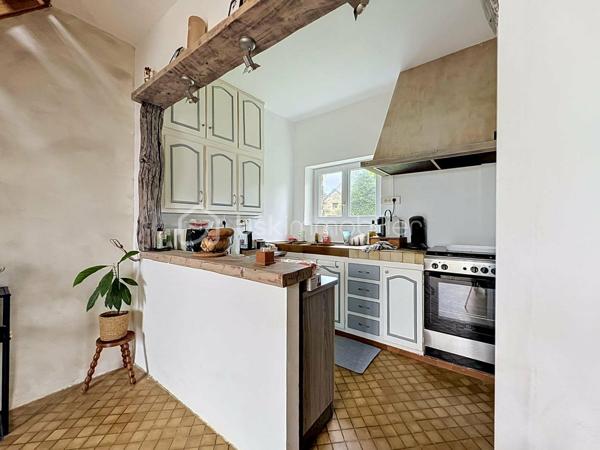 Si vous recherchez l'authenticité de la pierre, du caractère et de l'espace pour toute la famille, cette maison d'environ 98 m² (hors véranda) saura vous séduire. A quelques minutes de Bricquebec, cette maison de caractère avec ses poutres apparentes et ses volumes chaleureux est implantée sur une magnifique parcelle close et arborée de plus de 1 500 m².

​🛋️ Le rez-de-chaussée : De la lumière et du caractère. 🌞

L'accueil se fait par une agréable et lumineuse véranda qui sert d'entrée à la maison. Elle s'ouvre ensuite sur une belle pièce de vie de plus de 30 m² où le salon, réchauffé par une authentique cheminée avec insert, côtoie l'espace salle à manger. Une superbe poutre en bois brut vient rythmer cet espace sans le cloisonner.
La cuisine aménagée s'ouvre sur le séjour via un comptoir en bois très convivial, idéal pour déjeuner sur le pouce, et se prolonge par une arrière-cuisine (cellier) bien pratique.
Ce niveau propose également une suite avec sa chambre (bénéficiant d'une porte-fenêtre sur le jardin) et sa salle de bain privative avec baignoire et WC.

​🛌 L’étage : Le charme des boiseries et le coin nuit

L’escalier en bois dessert trois chambres mansardées au caractère authentique rehaussé par des poutres apparentes. L'une d'entre elles est idéale pour un espace bureau ou télétravail. Cet espace de nuit, fonctionnel, nécessite un petit rafraîchissement (peintures, papiers peints) pour révéler tout son potentiel et être mis à votre goût. Pour le confort de la famille au quotidien, ce niveau dispose d'une salle de douche et de deux WC.

​🌳 Les extérieurs et annexes : un vrai coup de cœur. 🧡

Le grand jardin accueille une terrasse d'environ 20 m² avec son barbecue fixe, prête pour les repas d'été.

✨ Le véritable atout caché ? Une superbe dépendance en pierre, déjà raccordée en eau et en électricité. Bien qu'elle nécessite une rénovation totale, elle offre un potentiel incroyable : futur gîte, atelier d'artiste ou studio d'invités.

Un cabanon de jardin fonctionnel (avec électricité et chauffage d'appoint) complètent le tout.