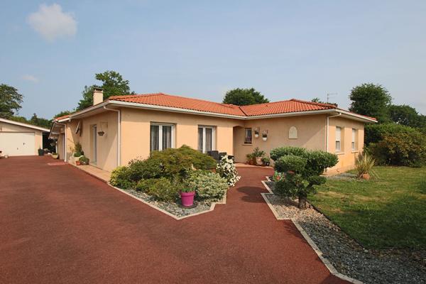 Plain-pied 4 chambres avec jardin paysagé et garage, proche commodités.