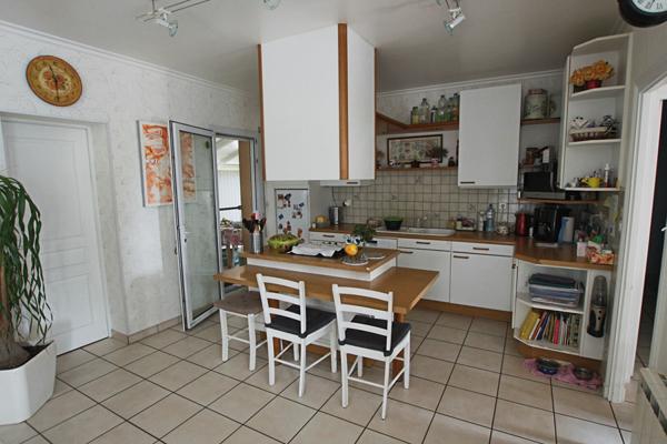 Plain-pied 4 chambres avec jardin paysagé et garage, proche commodités.