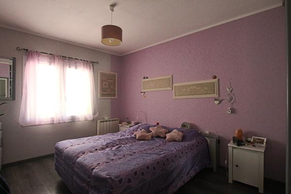 Plain-pied 4 chambres avec jardin paysagé et garage, proche commodités.