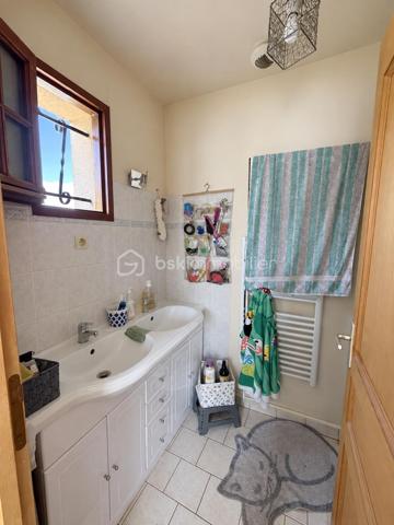 À Gasny (Eure, 27), au calme dans une impasse, cette maison lumineuse de 104 m² développe quatre chambres réparties sur deux niveaux, sur un terrain de 900 m². Grande pièce de vie avec cheminée à insert, chambre de plain-pied avec salle d'eau attenante, sous-sol total et terrasse composent un ensemble familial fonctionnel et bien agencé.

REZ-DE-CHAUSSÉE

La grande pièce de vie s'ouvre sur la cuisine, formant un espace unifié et lumineux, adapté aux moments du quotidien comme à la réception. Une cheminée à insert apporte chaleur et caractère à cet espace, tout en constituant un complément de chauffage appréciable en hiver. Ce niveau accueille également une chambre donnant sur une salle d'eau, configuration proche d'une suite qui permet une organisation de plain-pied, idéale pour des parents, des invités ou un usage sur le long terme. Un WC séparé complète le rez-de-chaussée, ainsi qu'un accès direct au sous-sol depuis l'intérieur.

À L'ÉTAGE

Un palier dessert trois chambres de bonne taille ainsi qu'une salle de bain avec toilettes. L'espace nuit de l'étage est ainsi clairement séparé des pièces de vie, avec des sanitaires présents à chaque niveau, une organisation pratique pour une famille avec enfants ou un foyer souhaitant dédier une pièce au télétravail.

SOUS-SOL TOTAL

Le grand sous-sol total, accessible depuis l'intérieur, bénéficie d'une bonne hauteur. Il offre un volume conséquent en complément de la surface habitable, utilisable en rangement, atelier, buanderie ou stationnement selon les besoins. Un atout concret, qui élargit sensiblement les possibilités d'usage du bien au quotidien.

EXTÉRIEUR

Le terrain de 900 m² offre un espace extérieur généreux, propice aux activités familiales, à l'aménagement paysager ou à un potager. Une terrasse prolonge la maison et permet de profiter des beaux jours en continuité avec les pièces de vie. Le terrain est sans vis-à-vis, ce qui garantit une vraie intimité dans l'usage de l'extérieur.

ENVIRONNEMENT ET ACCÈS

L'implantation en impasse assure une tranquillité réelle, avec une circulation limitée aux seuls riverains, un critère recherché par les familles, notamment pour la sécurité des enfants. Gasny se situe dans l'Eure, à proximité de Vernon et de la vallée de la Seine, dans un cadre verdoyant qui reste relié aux commerces, établissements scolaires et axes routiers du secteur.

POINTS À NOTER

Cette maison s'adresse aux familles recherchant un bien lumineux et fonctionnel, avec quatre chambres dont une de plain-pied, un sous-sol total et un grand terrain, dans un environnement calme.

Une maison familiale lumineuse de 104 m², avec sous-sol total et terrain de 900 m², au calme en impasse à Gasny.