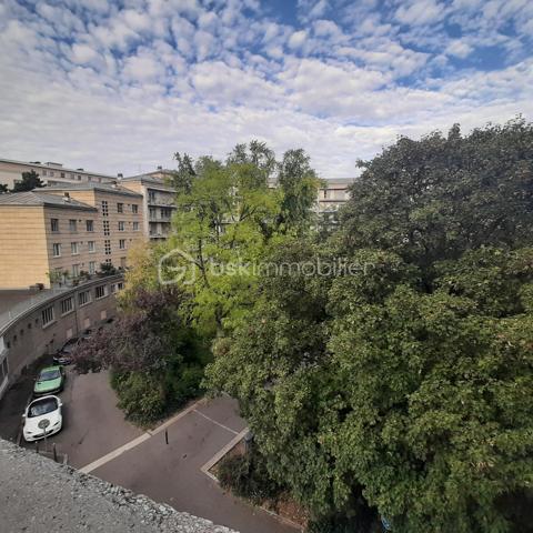 Situé au 3ᵉ étage du bâtiment annulaire, rue Auguste-Wicky à Mulhouse, cet appartement de 92 m² bénéficie d'un emplacement privilégié, à proximité immédiate de la gare et à deux pas du centre historique. Ses beaux volumes et sa configuration offrent de nombreuses possibilités d'aménagement.

Une adresse emblématique de Mulhouse
Construit dans les années 1950 par l'architecte Pierre-Jean Guth, le bâtiment annulaire est un édifice singulier de l'architecture mulhousienne d'après-guerre. Sa forme circulaire remarquable et son histoire lui ont valu une inscription au titre des monuments historiques en 2006. Une adresse de caractère, au cœur d'un ensemble architectural qui fait partie du patrimoine de la ville.

Un appartement à aménager selon votre projet
L'appartement se compose d'une large entrée, de quatre belles pièces de 11, 12, 16 et 17 m², offrant différentes possibilités d'aménagement selon les besoins de chacun. Une cuisine indépendante, une salle de bains, un WC séparé et un petit balcon complètent le bien.
Des travaux de rénovation sont à prévoir, laissant la possibilité de repenser les espaces et les prestations selon vos envies. Un devis a déjà été réalisé afin de permettre aux acquéreurs d'anticiper le budget nécessaire à leur projet.
À l'arrière de l'immeuble, la cour intérieure verdoyante entretenue par la Ville de Mulhouse apportent une touche de nature en milieu urbain. Le bien dispose également d'une cave. Des possibilités de stationnement existent à l'arrière de l'immeuble, sous réserve de disponibilité.

Que ce soit pour créer un lieu de vie personnalisé ou pour réaliser un investissement locatif, cet appartement présente un potentiel intéressant. Le règlement de copropriété autorise la location de courte durée, un atout supplémentaire pour les acquéreurs souhaitant étudier cette possibilité, sous réserve du respect de la réglementation applicable.

Informations complémentaires
- Surface : 92 m²
- Étage : 3ᵉ
- Chauffage collectif au gaz
- DPE : D — GES : D
- Taxe foncière : 1 200 € par an
- Charges annuelles comprennant charges générales de l'immeuble, eau chaude, eau froide et chauffage (5830€ de charges locatives sur 6283€ en 2025)