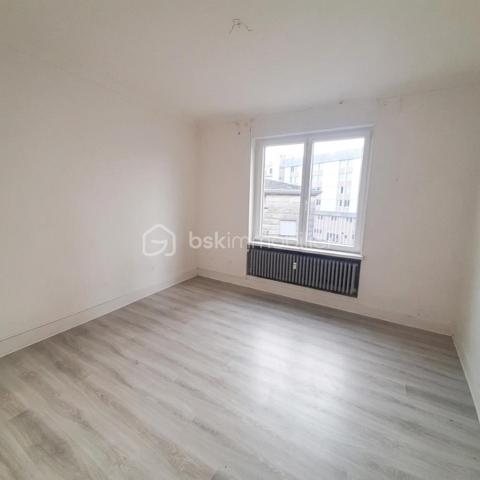 Situé au 3ᵉ étage du bâtiment annulaire, rue Auguste-Wicky à Mulhouse, cet appartement de 92 m² bénéficie d'un emplacement privilégié, à proximité immédiate de la gare et à deux pas du centre historique. Ses beaux volumes et sa configuration offrent de nombreuses possibilités d'aménagement.

Une adresse emblématique de Mulhouse
Construit dans les années 1950 par l'architecte Pierre-Jean Guth, le bâtiment annulaire est un édifice singulier de l'architecture mulhousienne d'après-guerre. Sa forme circulaire remarquable et son histoire lui ont valu une inscription au titre des monuments historiques en 2006. Une adresse de caractère, au cœur d'un ensemble architectural qui fait partie du patrimoine de la ville.

Un appartement à aménager selon votre projet
L'appartement se compose d'une large entrée, de quatre belles pièces de 11, 12, 16 et 17 m², offrant différentes possibilités d'aménagement selon les besoins de chacun. Une cuisine indépendante, une salle de bains, un WC séparé et un petit balcon complètent le bien.
Des travaux de rénovation sont à prévoir, laissant la possibilité de repenser les espaces et les prestations selon vos envies. Un devis a déjà été réalisé afin de permettre aux acquéreurs d'anticiper le budget nécessaire à leur projet.
À l'arrière de l'immeuble, la cour intérieure verdoyante entretenue par la Ville de Mulhouse apportent une touche de nature en milieu urbain. Le bien dispose également d'une cave. Des possibilités de stationnement existent à l'arrière de l'immeuble, sous réserve de disponibilité.

Que ce soit pour créer un lieu de vie personnalisé ou pour réaliser un investissement locatif, cet appartement présente un potentiel intéressant. Le règlement de copropriété autorise la location de courte durée, un atout supplémentaire pour les acquéreurs souhaitant étudier cette possibilité, sous réserve du respect de la réglementation applicable.

Informations complémentaires
- Surface : 92 m²
- Étage : 3ᵉ
- Chauffage collectif au gaz
- DPE : D — GES : D
- Taxe foncière : 1 200 € par an
- Charges annuelles comprennant charges générales de l'immeuble, eau chaude, eau froide et chauffage (5830€ de charges locatives sur 6283€ en 2025)