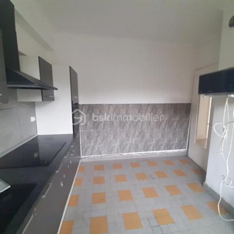 Situé au 3ᵉ étage du bâtiment annulaire, rue Auguste-Wicky à Mulhouse, cet appartement de 92 m² bénéficie d'un emplacement privilégié, à proximité immédiate de la gare et à deux pas du centre historique. Ses beaux volumes et sa configuration offrent de nombreuses possibilités d'aménagement.

Une adresse emblématique de Mulhouse
Construit dans les années 1950 par l'architecte Pierre-Jean Guth, le bâtiment annulaire est un édifice singulier de l'architecture mulhousienne d'après-guerre. Sa forme circulaire remarquable et son histoire lui ont valu une inscription au titre des monuments historiques en 2006. Une adresse de caractère, au cœur d'un ensemble architectural qui fait partie du patrimoine de la ville.

Un appartement à aménager selon votre projet
L'appartement se compose d'une large entrée, de quatre belles pièces de 11, 12, 16 et 17 m², offrant différentes possibilités d'aménagement selon les besoins de chacun. Une cuisine indépendante, une salle de bains, un WC séparé et un petit balcon complètent le bien.
Des travaux de rénovation sont à prévoir, laissant la possibilité de repenser les espaces et les prestations selon vos envies. Un devis a déjà été réalisé afin de permettre aux acquéreurs d'anticiper le budget nécessaire à leur projet.
À l'arrière de l'immeuble, la cour intérieure verdoyante entretenue par la Ville de Mulhouse apportent une touche de nature en milieu urbain. Le bien dispose également d'une cave. Des possibilités de stationnement existent à l'arrière de l'immeuble, sous réserve de disponibilité.

Que ce soit pour créer un lieu de vie personnalisé ou pour réaliser un investissement locatif, cet appartement présente un potentiel intéressant. Le règlement de copropriété autorise la location de courte durée, un atout supplémentaire pour les acquéreurs souhaitant étudier cette possibilité, sous réserve du respect de la réglementation applicable.

Informations complémentaires
- Surface : 92 m²
- Étage : 3ᵉ
- Chauffage collectif au gaz
- DPE : D — GES : D
- Taxe foncière : 1 200 € par an
- Charges annuelles comprennant charges générales de l'immeuble, eau chaude, eau froide et chauffage (5830€ de charges locatives sur 6283€ en 2025)