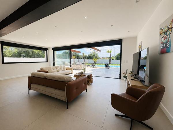 Cette villa de plus de 270 m² aux volumes généreux, implantée sur un terrain de 1 860 m², offre des prestations de qualité et un cadre de vie privilégié.
 
Dès l’entrée, vous découvrirez un vaste hall avec placard ainsi qu’un toilette indépendant. La pièce de vie principale, particulièrement belle et lumineuse, développe environ 65 m² et réunit le salon, le séjour et la cuisine ouverte. Cet espace bénéficie d’une magnifique baie vitrée de 6 mètres sur trois vantaux, dont une ouverture de 4 mètres, ainsi que d’une grande fenêtre fixe dans le salon.
Ces menuiseries en aluminium apportent une luminosité exceptionnelle et offrent une parfaite continuité entre l’intérieur et l’extérieur.

Cette vaste pièce de vie s’ouvre directement sur une superbe terrasse d’environ 130 m², véritable espace de réception et de détente. Vous y découvrirez une magnifique piscine au sel entièrement automatisée de 8 x 4 mètres, entourée d’une élégante terrasse en bois et d’un agréable espace paysager offrant un beau coin de verdure propice à la détente. Un grand terrain de pétanque vient compléter cet environnement extérieur pensé pour les moments de convivialité en famille ou entre amis.

La suite parentale d’environ 35 m² constitue un véritable univers intimiste avec son dressing et sa salle de bains équipée d’une double vasque, d’une double douche et d’une baignoire.

L’espace nuit accueille trois chambres d’environ 14 m² chacune, disposant toutes de leur propre salle d’eau. L’une d’entre elles bénéficie en outre d’un agréable balcon privatif. Un second toilette indépendant complète cet espace.

Au sous-sol, vous profiterez d’une salle de jeux et de cinéma d’environ 60 m² ainsi que d’une buanderie d’une dizaine de mètres carrés. Un espace supplémentaire d’environ 40 m² reste encore aménageable selon vos besoins et vos projets : salle de sport, zone bien-être, cave à vin, bureau ou chambres complémentaires.

Une dépendance d’environ 45 m² complète ce bien. Accessible aussi bien par l’extérieur que directement depuis le sous sol de la maison, elle se compose d’une chambre avec salle d’eau privative et rangement, d’un toilette séparé, d’une cuisine indépendante et d’un séjour avec coin repas. Elle bénéficie également de sa propre terrasse privative offrant un espace extérieur agréable et indépendant. 
Cet ensemble offre une totale autonomie et conviendra parfaitement pour accueillir famille et amis ou développer un projet locatif.

À l’extérieur, deux abris de jardin de respectivement 40 m² et 30 m² offrent un potentiel supplémentaire important. Ils pourront être aménagés selon vos envies en bureau, atelier, espace professionnel ou zone de stockage.

La propriété dispose également d’une borne de recharge universelle pour véhicule électrique, elle est raccordée au tout-à-l’égout et bénéficie de capteurs photovoltaïques contribuant à la production d’énergie et à la maîtrise des dépenses énergétiques.

Pour un confort optimal en toutes saisons, la maison est entièrement équipée d’un système de climatisation réversible par split indépendant, permettant à chaque pièce de bénéficier d’un réglage personnalisé.

L’ensemble des menuiseries de la maison est en PVC double vitrage, garantissant une excellente isolation thermique et phonique. Seules la baie vitrée de 6 mètres et la grande fenêtre fixe du salon sont en aluminium, offrant à la fois élégance, robustesse et apport maximal de lumière naturelle.

Rare sur le marché, cette propriété séduit par ses volumes, sa luminosité, ses prestations de qualité, ses espaces extérieurs parfaitement aménagés et les nombreuses possibilités qu’elle offre. Entre la piscine automatisée, la dépendance, le sous sol, les espaces aménageables et les équipements modernes, tout a été pensé pour offrir un confort de vie exceptionnel.

Une visite s’impose pour découvrir tout le potentiel et le charme de cette propriété d’exception.
Coup de cœur assuré !