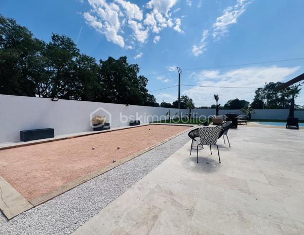 Cette villa de plus de 270 m² aux volumes généreux, implantée sur un terrain de 1 860 m², offre des prestations de qualité et un cadre de vie privilégié.
 
Dès l’entrée, vous découvrirez un vaste hall avec placard ainsi qu’un toilette indépendant. La pièce de vie principale, particulièrement belle et lumineuse, développe environ 65 m² et réunit le salon, le séjour et la cuisine ouverte. Cet espace bénéficie d’une magnifique baie vitrée de 6 mètres sur trois vantaux, dont une ouverture de 4 mètres, ainsi que d’une grande fenêtre fixe dans le salon.
Ces menuiseries en aluminium apportent une luminosité exceptionnelle et offrent une parfaite continuité entre l’intérieur et l’extérieur.

Cette vaste pièce de vie s’ouvre directement sur une superbe terrasse d’environ 130 m², véritable espace de réception et de détente. Vous y découvrirez une magnifique piscine au sel entièrement automatisée de 8 x 4 mètres, entourée d’une élégante terrasse en bois et d’un agréable espace paysager offrant un beau coin de verdure propice à la détente. Un grand terrain de pétanque vient compléter cet environnement extérieur pensé pour les moments de convivialité en famille ou entre amis.

La suite parentale d’environ 35 m² constitue un véritable univers intimiste avec son dressing et sa salle de bains équipée d’une double vasque, d’une double douche et d’une baignoire.

L’espace nuit accueille trois chambres d’environ 14 m² chacune, disposant toutes de leur propre salle d’eau. L’une d’entre elles bénéficie en outre d’un agréable balcon privatif. Un second toilette indépendant complète cet espace.

Au sous-sol, vous profiterez d’une salle de jeux et de cinéma d’environ 60 m² ainsi que d’une buanderie d’une dizaine de mètres carrés. Un espace supplémentaire d’environ 40 m² reste encore aménageable selon vos besoins et vos projets : salle de sport, zone bien-être, cave à vin, bureau ou chambres complémentaires.

Une dépendance d’environ 45 m² complète ce bien. Accessible aussi bien par l’extérieur que directement depuis le sous sol de la maison, elle se compose d’une chambre avec salle d’eau privative et rangement, d’un toilette séparé, d’une cuisine indépendante et d’un séjour avec coin repas. Elle bénéficie également de sa propre terrasse privative offrant un espace extérieur agréable et indépendant. 
Cet ensemble offre une totale autonomie et conviendra parfaitement pour accueillir famille et amis ou développer un projet locatif.

À l’extérieur, deux abris de jardin de respectivement 40 m² et 30 m² offrent un potentiel supplémentaire important. Ils pourront être aménagés selon vos envies en bureau, atelier, espace professionnel ou zone de stockage.

La propriété dispose également d’une borne de recharge universelle pour véhicule électrique, elle est raccordée au tout-à-l’égout et bénéficie de capteurs photovoltaïques contribuant à la production d’énergie et à la maîtrise des dépenses énergétiques.

Pour un confort optimal en toutes saisons, la maison est entièrement équipée d’un système de climatisation réversible par split indépendant, permettant à chaque pièce de bénéficier d’un réglage personnalisé.

L’ensemble des menuiseries de la maison est en PVC double vitrage, garantissant une excellente isolation thermique et phonique. Seules la baie vitrée de 6 mètres et la grande fenêtre fixe du salon sont en aluminium, offrant à la fois élégance, robustesse et apport maximal de lumière naturelle.

Rare sur le marché, cette propriété séduit par ses volumes, sa luminosité, ses prestations de qualité, ses espaces extérieurs parfaitement aménagés et les nombreuses possibilités qu’elle offre. Entre la piscine automatisée, la dépendance, le sous sol, les espaces aménageables et les équipements modernes, tout a été pensé pour offrir un confort de vie exceptionnel.

Une visite s’impose pour découvrir tout le potentiel et le charme de cette propriété d’exception.
Coup de cœur assuré !