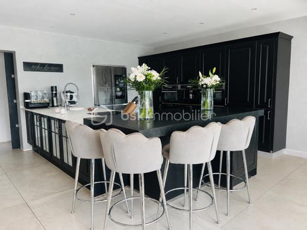 Cette villa de plus de 270 m² aux volumes généreux, implantée sur un terrain de 1 860 m², offre des prestations de qualité et un cadre de vie privilégié.
 
Dès l’entrée, vous découvrirez un vaste hall avec placard ainsi qu’un toilette indépendant. La pièce de vie principale, particulièrement belle et lumineuse, développe environ 65 m² et réunit le salon, le séjour et la cuisine ouverte. Cet espace bénéficie d’une magnifique baie vitrée de 6 mètres sur trois vantaux, dont une ouverture de 4 mètres, ainsi que d’une grande fenêtre fixe dans le salon.
Ces menuiseries en aluminium apportent une luminosité exceptionnelle et offrent une parfaite continuité entre l’intérieur et l’extérieur.

Cette vaste pièce de vie s’ouvre directement sur une superbe terrasse d’environ 130 m², véritable espace de réception et de détente. Vous y découvrirez une magnifique piscine au sel entièrement automatisée de 8 x 4 mètres, entourée d’une élégante terrasse en bois et d’un agréable espace paysager offrant un beau coin de verdure propice à la détente. Un grand terrain de pétanque vient compléter cet environnement extérieur pensé pour les moments de convivialité en famille ou entre amis.

La suite parentale d’environ 35 m² constitue un véritable univers intimiste avec son dressing et sa salle de bains équipée d’une double vasque, d’une double douche et d’une baignoire.

L’espace nuit accueille trois chambres d’environ 14 m² chacune, disposant toutes de leur propre salle d’eau. L’une d’entre elles bénéficie en outre d’un agréable balcon privatif. Un second toilette indépendant complète cet espace.

Au sous-sol, vous profiterez d’une salle de jeux et de cinéma d’environ 60 m² ainsi que d’une buanderie d’une dizaine de mètres carrés. Un espace supplémentaire d’environ 40 m² reste encore aménageable selon vos besoins et vos projets : salle de sport, zone bien-être, cave à vin, bureau ou chambres complémentaires.

Une dépendance d’environ 45 m² complète ce bien. Accessible aussi bien par l’extérieur que directement depuis le sous sol de la maison, elle se compose d’une chambre avec salle d’eau privative et rangement, d’un toilette séparé, d’une cuisine indépendante et d’un séjour avec coin repas. Elle bénéficie également de sa propre terrasse privative offrant un espace extérieur agréable et indépendant. 
Cet ensemble offre une totale autonomie et conviendra parfaitement pour accueillir famille et amis ou développer un projet locatif.

À l’extérieur, deux abris de jardin de respectivement 40 m² et 30 m² offrent un potentiel supplémentaire important. Ils pourront être aménagés selon vos envies en bureau, atelier, espace professionnel ou zone de stockage.

La propriété dispose également d’une borne de recharge universelle pour véhicule électrique, elle est raccordée au tout-à-l’égout et bénéficie de capteurs photovoltaïques contribuant à la production d’énergie et à la maîtrise des dépenses énergétiques.

Pour un confort optimal en toutes saisons, la maison est entièrement équipée d’un système de climatisation réversible par split indépendant, permettant à chaque pièce de bénéficier d’un réglage personnalisé.

L’ensemble des menuiseries de la maison est en PVC double vitrage, garantissant une excellente isolation thermique et phonique. Seules la baie vitrée de 6 mètres et la grande fenêtre fixe du salon sont en aluminium, offrant à la fois élégance, robustesse et apport maximal de lumière naturelle.

Rare sur le marché, cette propriété séduit par ses volumes, sa luminosité, ses prestations de qualité, ses espaces extérieurs parfaitement aménagés et les nombreuses possibilités qu’elle offre. Entre la piscine automatisée, la dépendance, le sous sol, les espaces aménageables et les équipements modernes, tout a été pensé pour offrir un confort de vie exceptionnel.

Une visite s’impose pour découvrir tout le potentiel et le charme de cette propriété d’exception.
Coup de cœur assuré !
