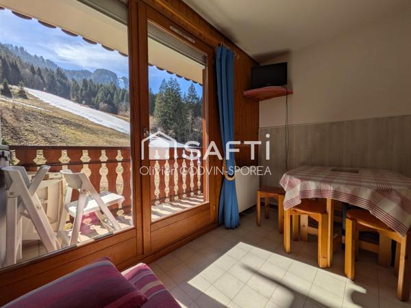Studio cabine de 23m2 avec balcon exposé sud et casier à ski offrant une vue dégagée sur les alpages et montagnes environnantes.