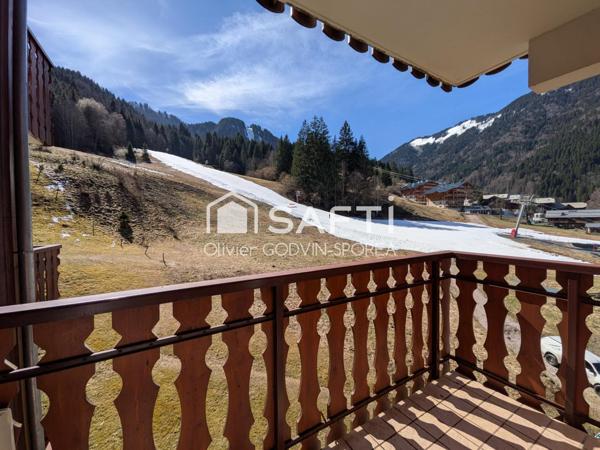 Studio cabine de 23m2 avec balcon exposé sud et casier à ski offrant une vue dégagée sur les alpages et montagnes environnantes.