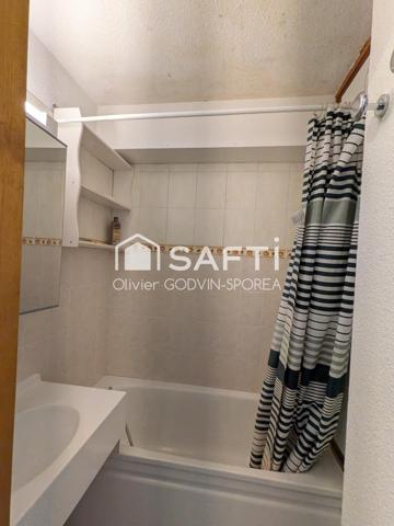 Studio cabine de 23m2 avec balcon exposé sud et casier à ski offrant une vue dégagée sur les alpages et montagnes environnantes.