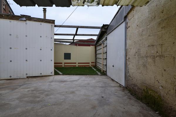 Maison de ville de 102m² en semi plain pied, 2 chambres, 1 bureau avec garage, cour et jardinet.