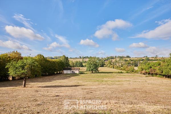 Maison en pierre rénovée et dépendances face au paysage vallonné