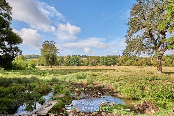 Maison en pierre rénovée et dépendances face au paysage vallonné