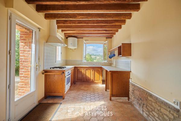 Maison en pierre rénovée et dépendances face au paysage vallonné