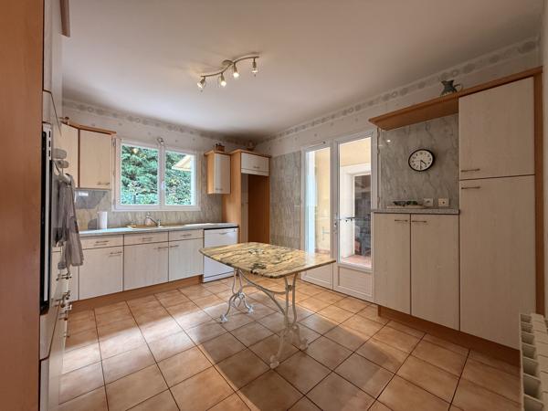 Maison de plain-pied avec véranda, garage et beau jardin clos dans un quartier recherché