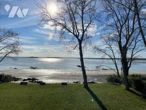 En première ligne face à la mer, au sein d'une maison de maître implantée sur un terrain arboré...